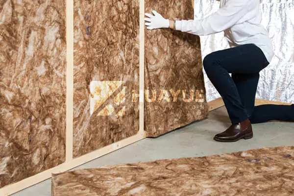 A cutaway view of a 2x4 wall showing perfectly fitted fiberglass insulation batts