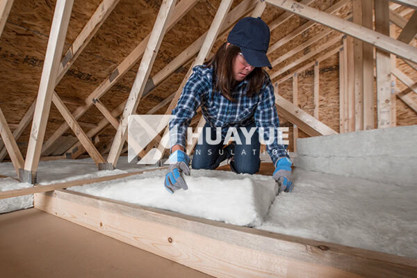 A well-lit, clean attic showing pristine fiberglass insulation between joists
