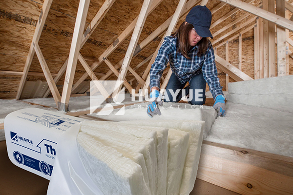 detailed image of fiberglass insulation batt being fitted into wall cavity