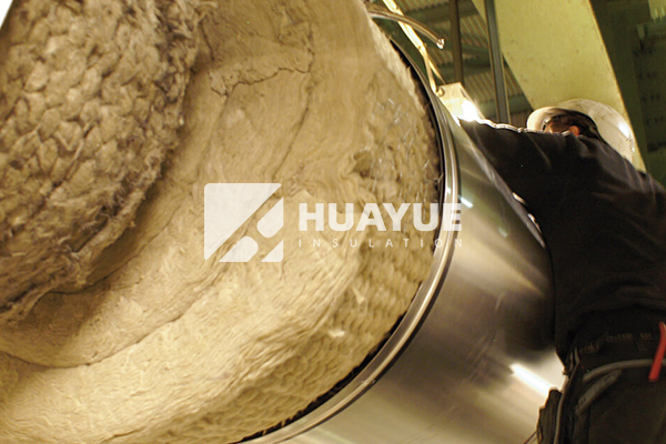 workers installing rock wool on industrial tanks