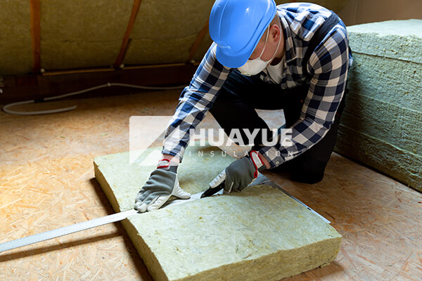 workers installing rock wool insulation with protective masks
