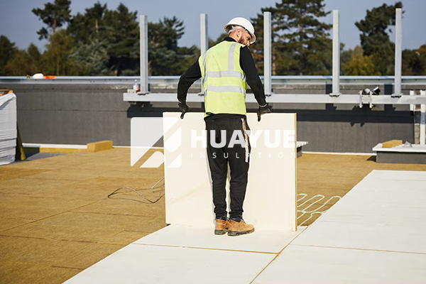 application image: rock wool flat roof insulation being installed on a commercial building